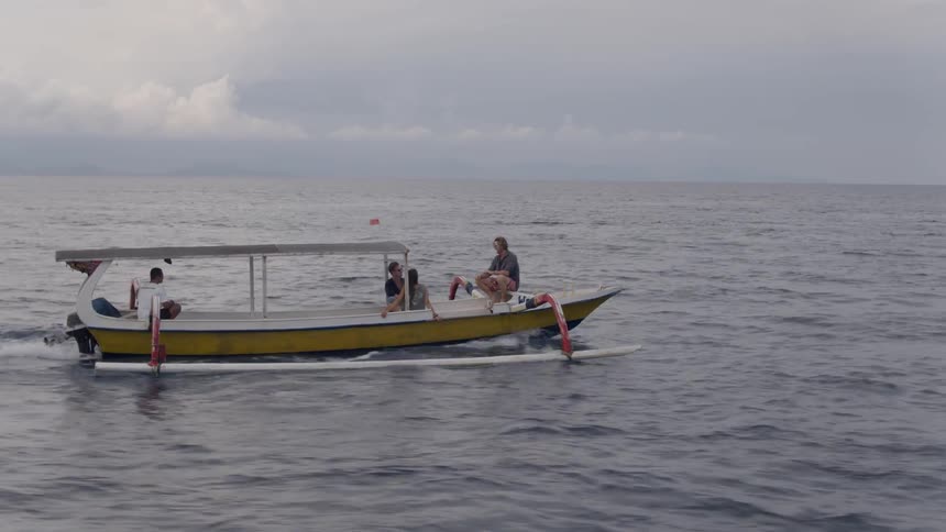 People are riding on a boat on the ocean on a cloudy day