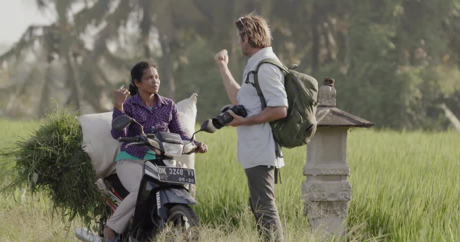 A photographer talks to a woman on a scooter