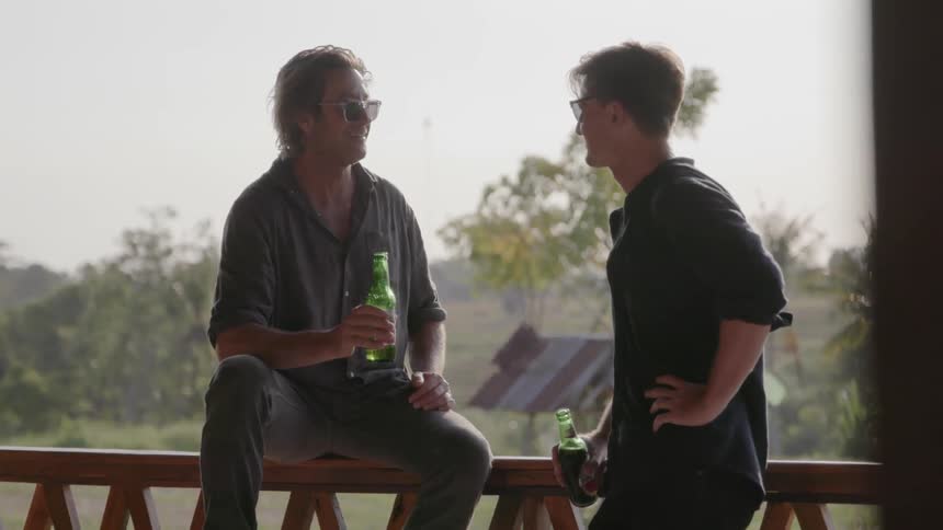 Men on porch talking and drinking beer