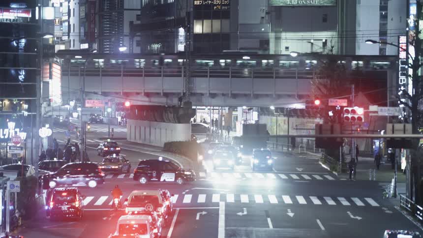 Cars drive on a city street at night