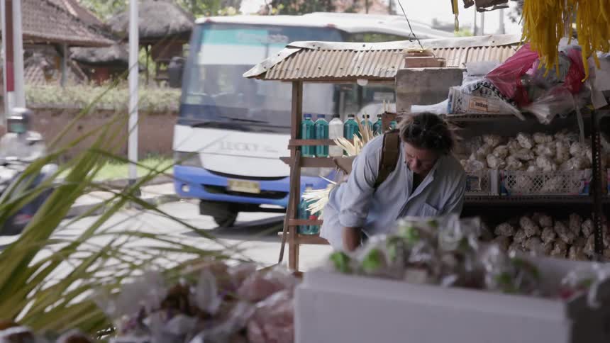 Man with satchel examines fresh produce