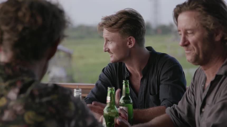 Men drink and chat on a patio