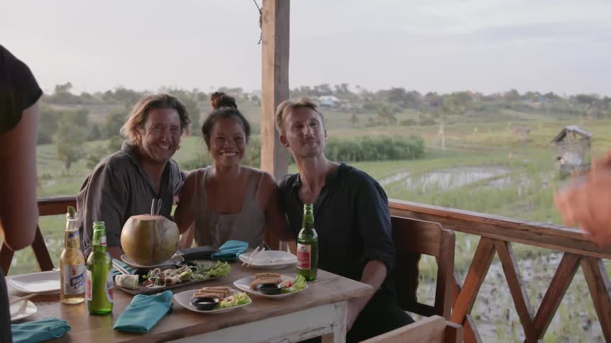 Friends pose for a picture while eating on a patio