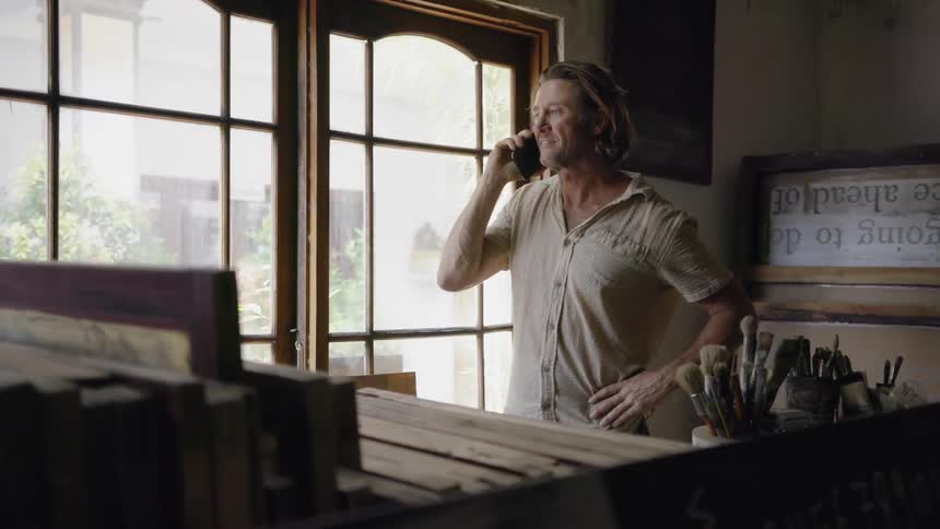 Man talks on the phone in an art studio