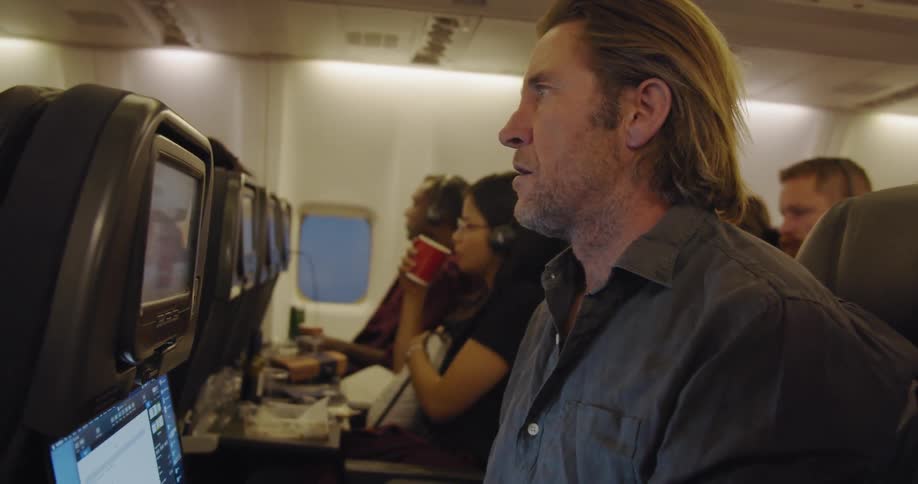 Man works on a laptop during a flight