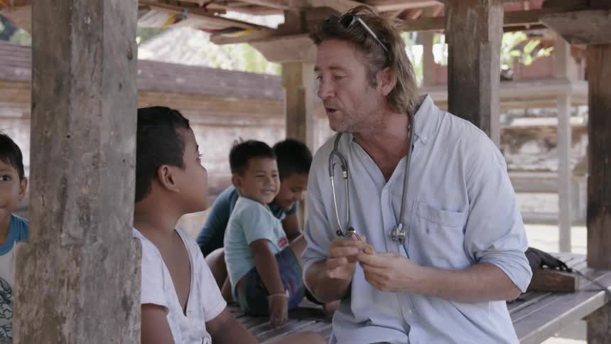 A physician examines a young boy in a village