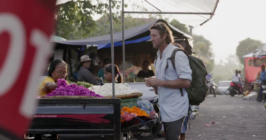 Man shops for flowers at a farmer's market
