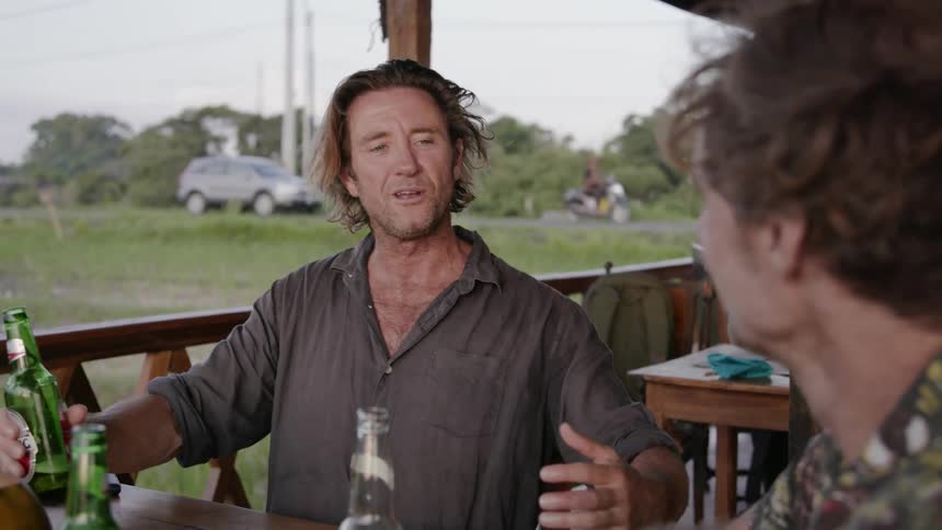 Men drink beer and chat on a patio
