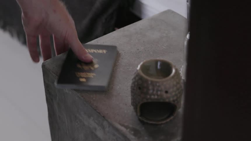 A man picks a passport off the table