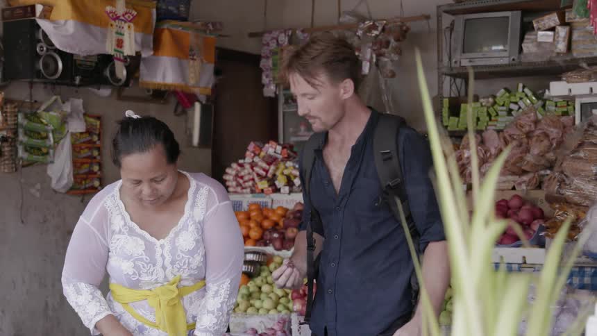 A man tastes a sample in a woman's market