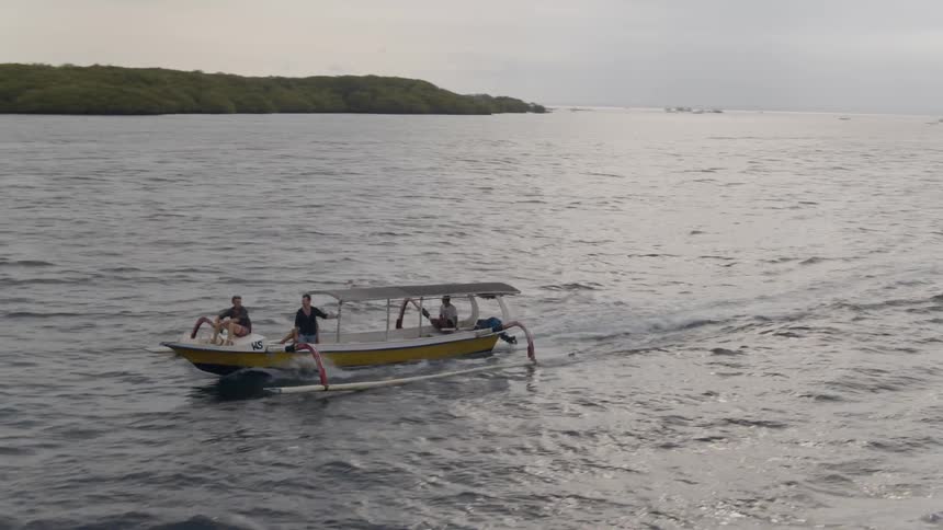 Two men are riding on a boat as it speeds across the ocean on a cloudy day