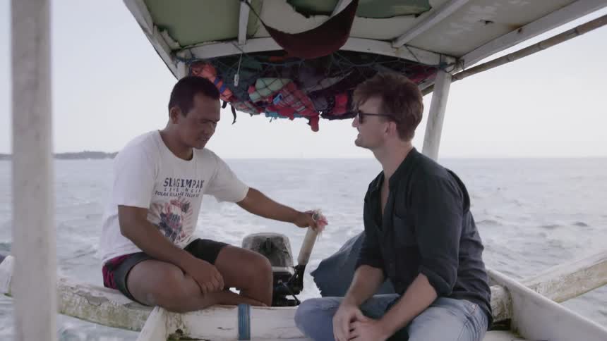 Two men talk as they ride in a boat