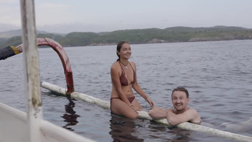 A man and woman laugh in the water together