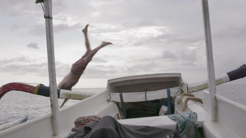 A man dives off a boat into the water