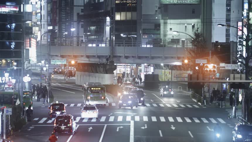 Vehicles and pedestrians commute in the city at night
