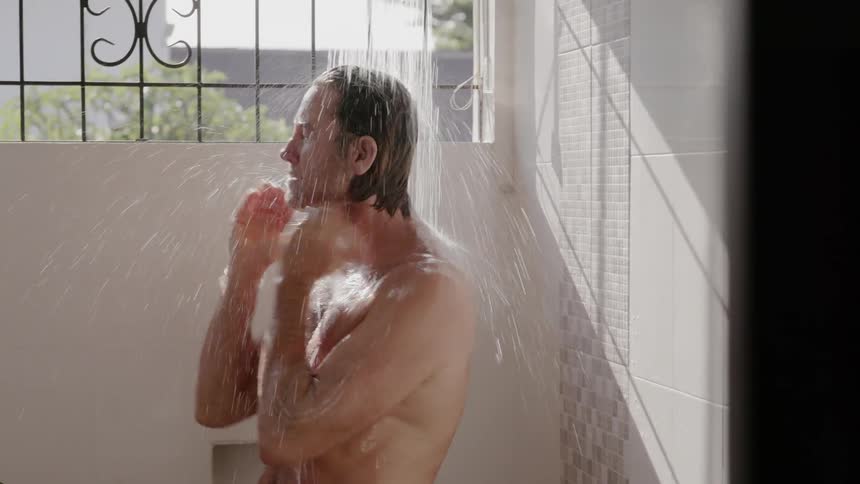 A man scrubs his body in the shower