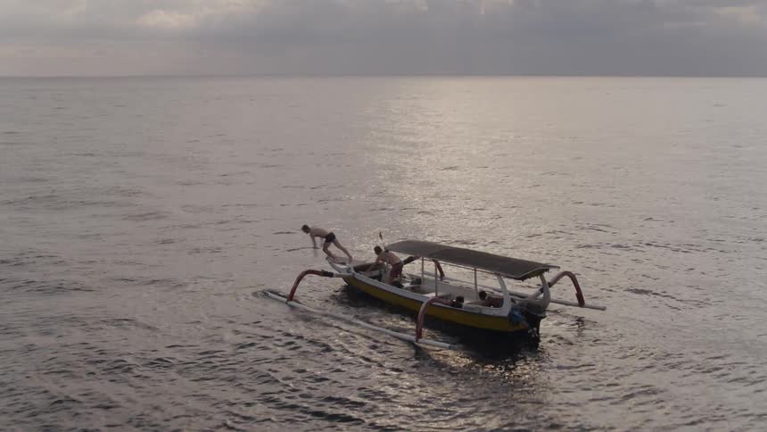 A man dives off a boat into the water