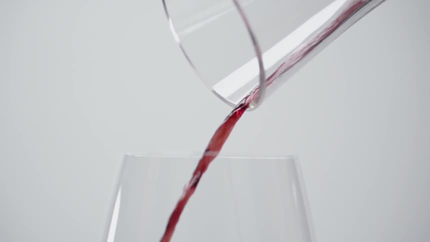 Red wine is poured into a glass