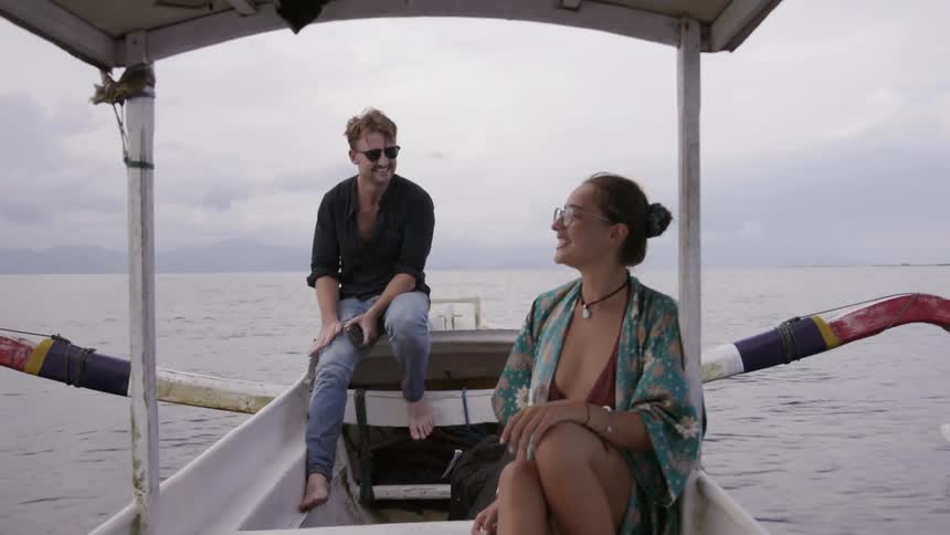 Man and woman smile while boating on the ocean