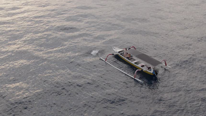 A man jumps off a boat into the ocean