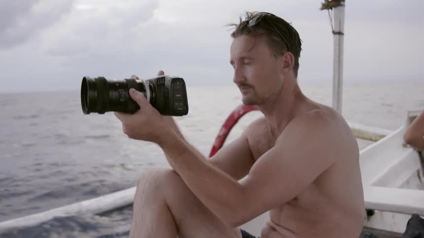 Man on boat takes video with camera