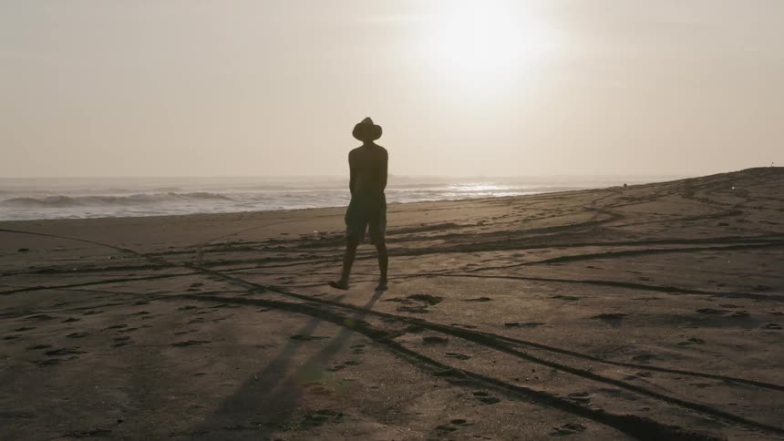 Woman walks on the beach in the morning
