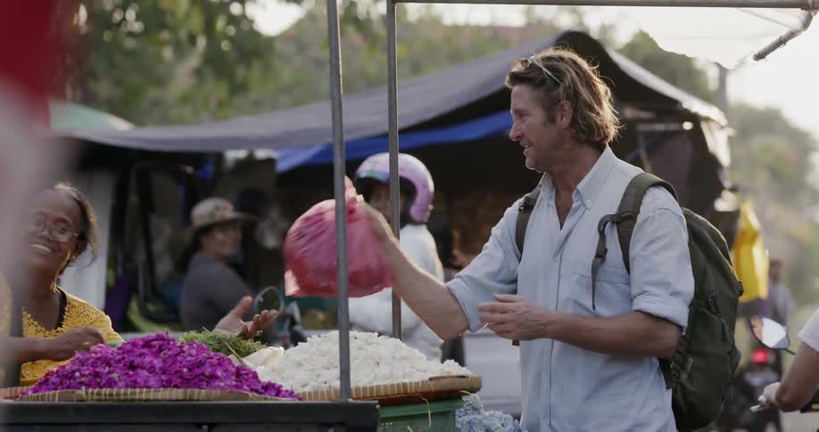 Man buys produce at an outdoor market
