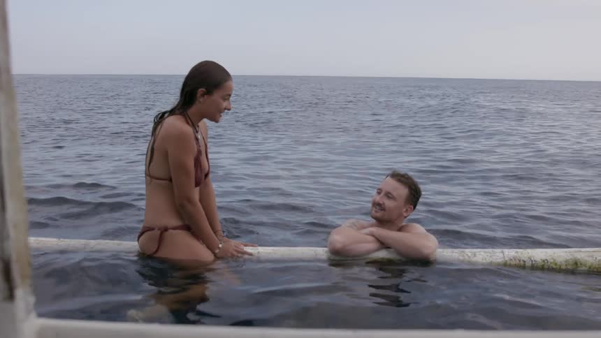 Man and woman talking in the water while swimming