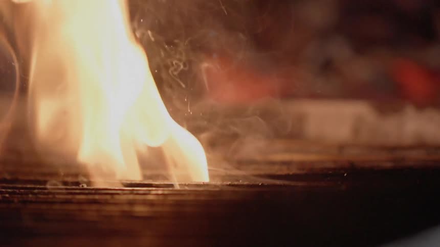 A steak cooks on a grill