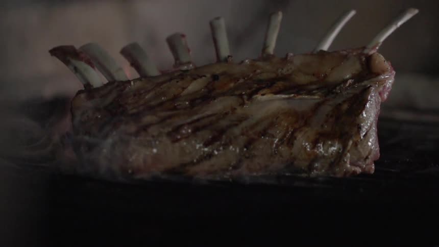 A rack of ribs are cooking on grill