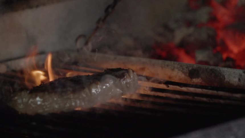 The steak is cooking on the hot grill