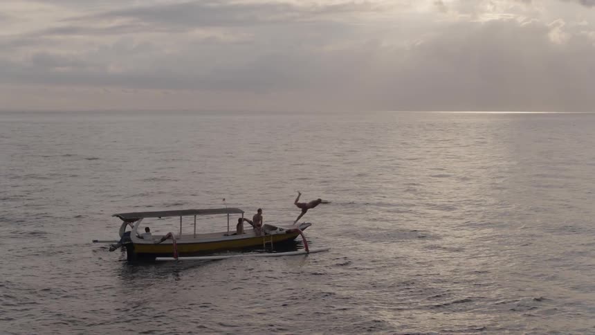 A man on the boat dives into the water