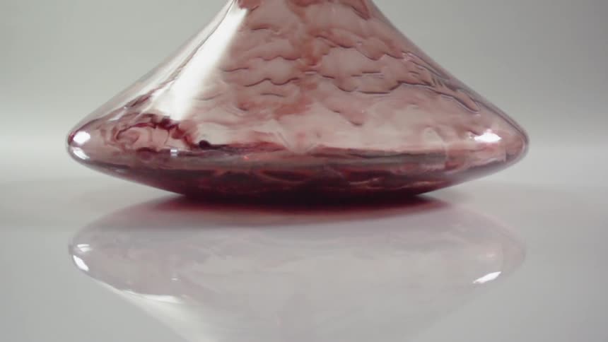 Red wine is poured into a decanter