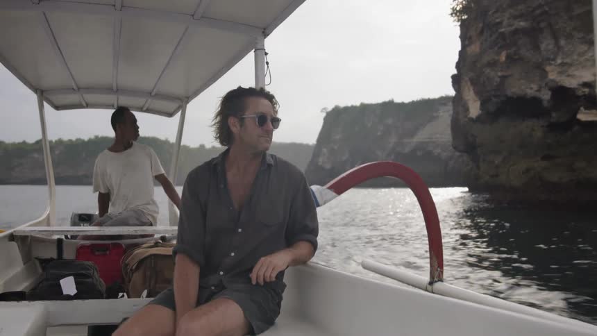 A man rides on a boat in the water