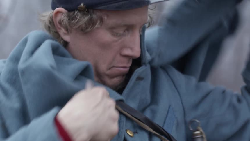 Man adjusts the cape on his coat