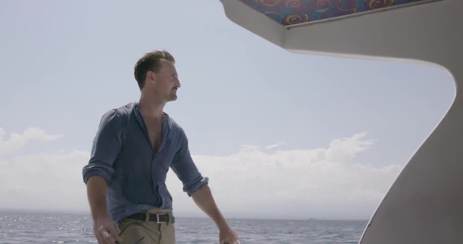 Man takes off his sunglasses on a boat
