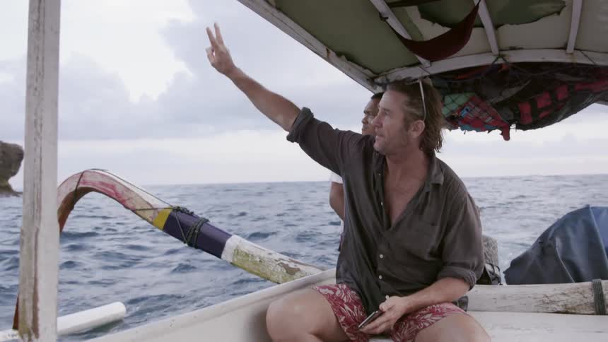 Man rides in a boat on an ocean