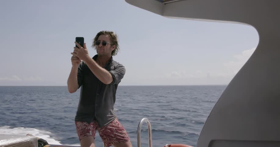 Man on boat takes photo with phone
