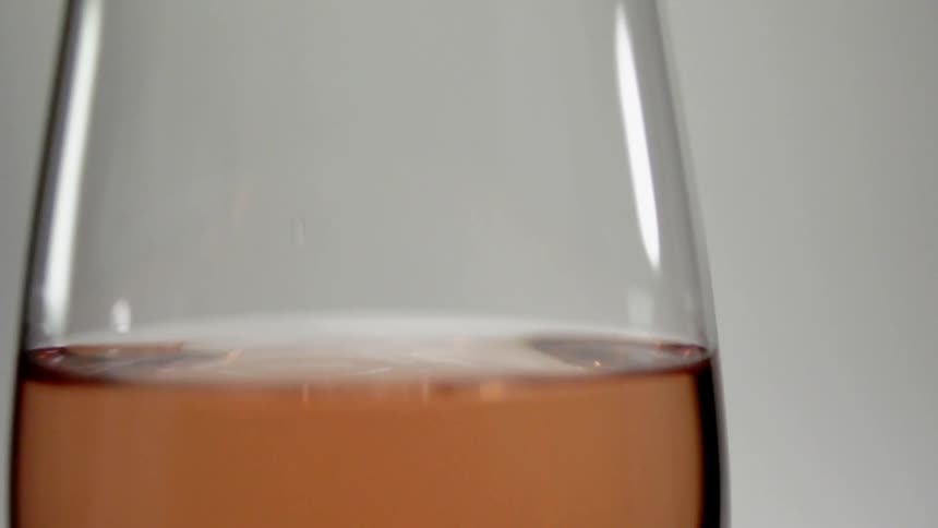 A drop of wine splashes in a glass
