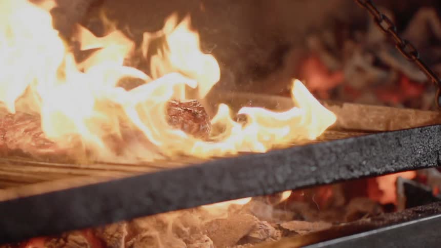A steak cooks on a grill