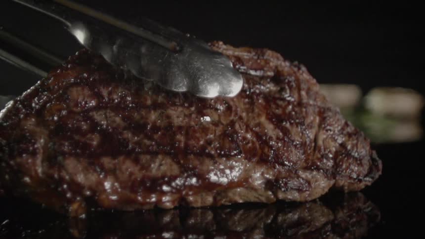 A cooked steak is put on a plate