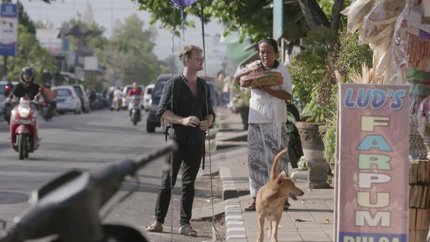 A man and woman talk on the busy street