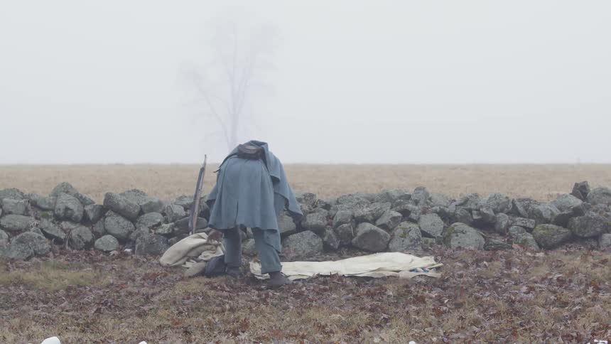 A soldier lays a blanket on the ground