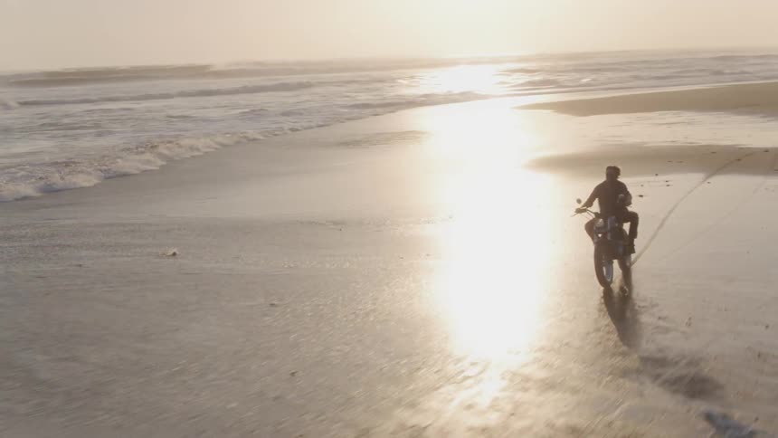 A man rides a motorcycle on the beach