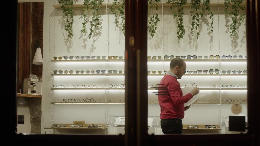 A man looks at glasses on display in a store