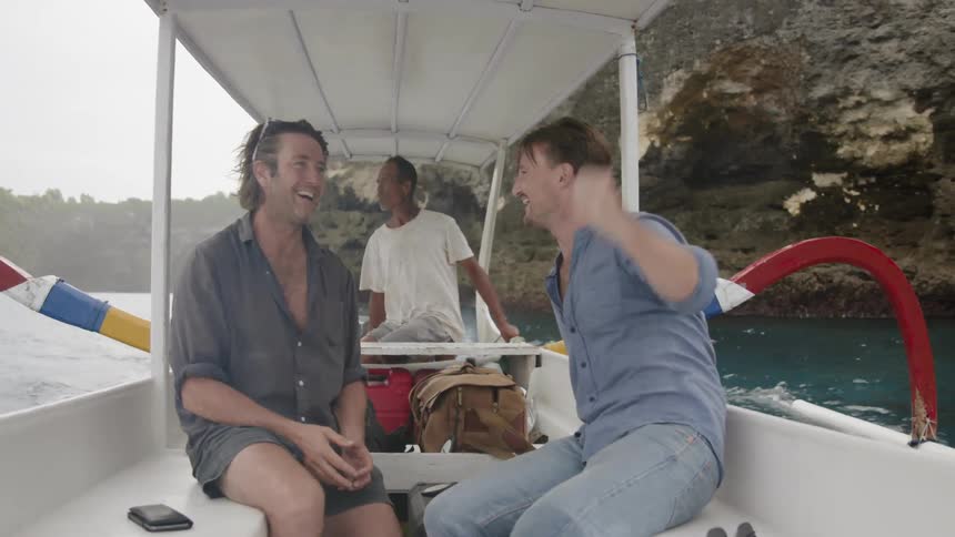 Men ride on boat talking and laughing