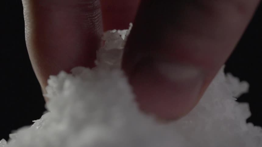 A person lifts a pinch of salt up
