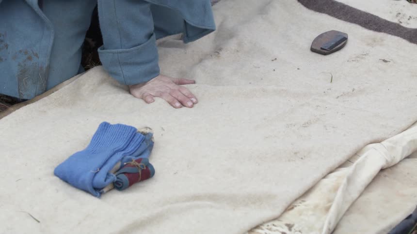 A soldier sets out his belongings on a blanket