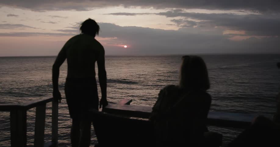 A man jumps in the water at dawn