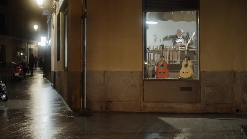 A man is working in the guitar shop on the corner